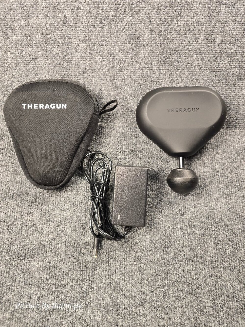 Therabody Theragun Mini portable percussion massage gun.